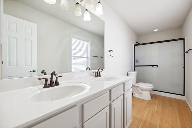 bathroom with vanity, hardwood / wood-style flooring, a shower with shower door, and toilet