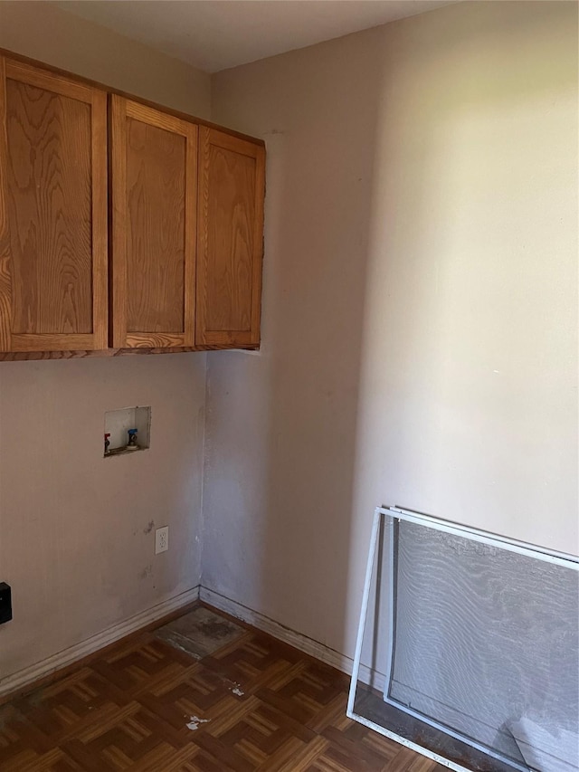 laundry room with washer hookup, dark parquet floors, and cabinets