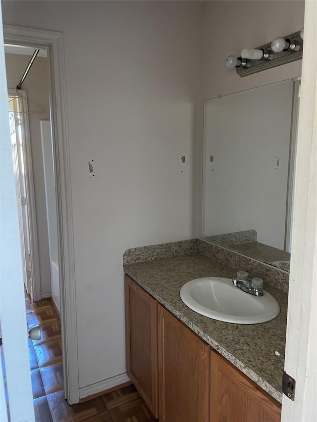 bathroom with parquet flooring, vanity, and bathing tub / shower combination