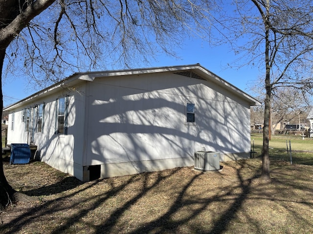 view of side of home with central AC