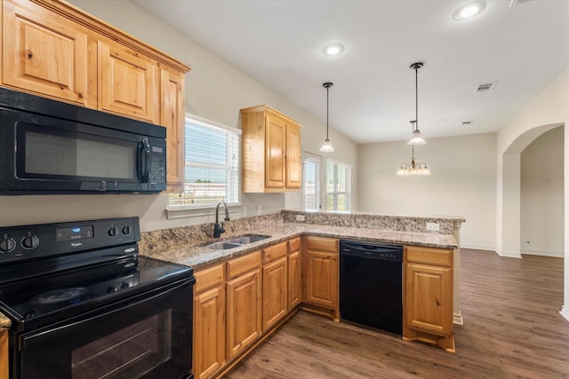 kitchen with dark hardwood / wood-style floors, black appliances, sink, hanging light fixtures, and kitchen peninsula