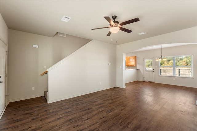 unfurnished living room featuring dark wood-type flooring and ceiling fan with notable chandelier