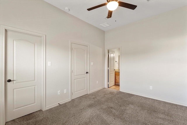 unfurnished bedroom featuring ceiling fan, ensuite bath, and light carpet