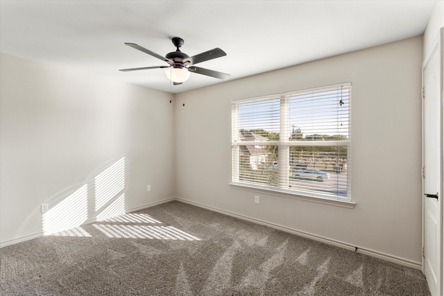 carpeted spare room featuring ceiling fan