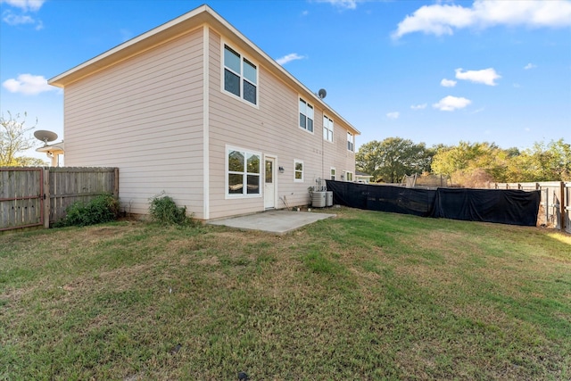 back of house featuring a patio, a yard, and central AC