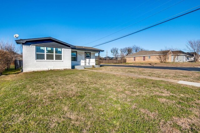 ranch-style house with a porch and a front lawn