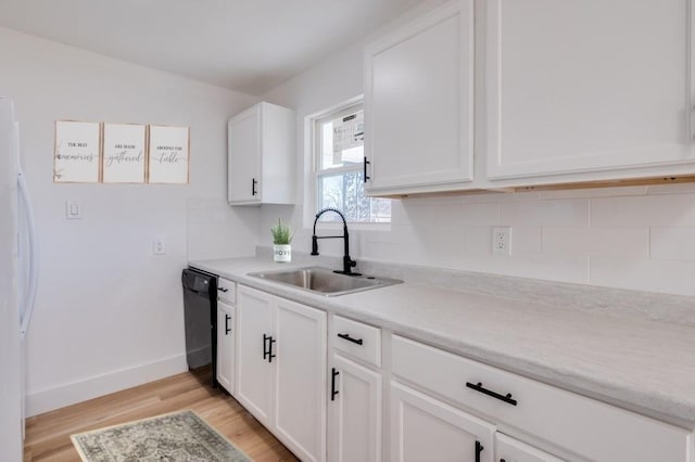 kitchen featuring light hardwood / wood-style flooring, white cabinets, white fridge, sink, and black dishwasher