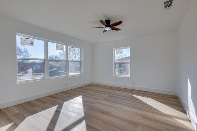 unfurnished room featuring visible vents, light wood-style flooring, and baseboards