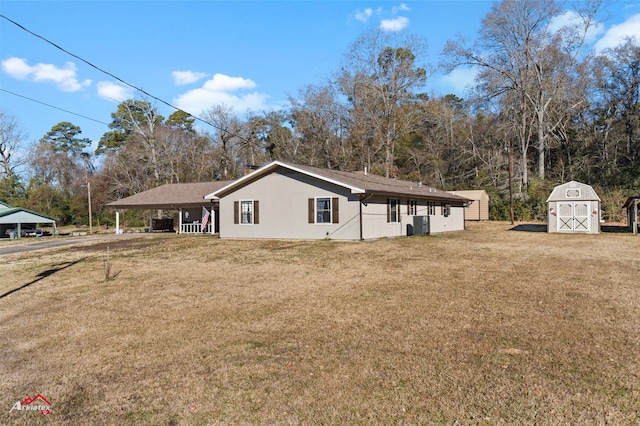 view of side of property with a carport, a shed, and a lawn