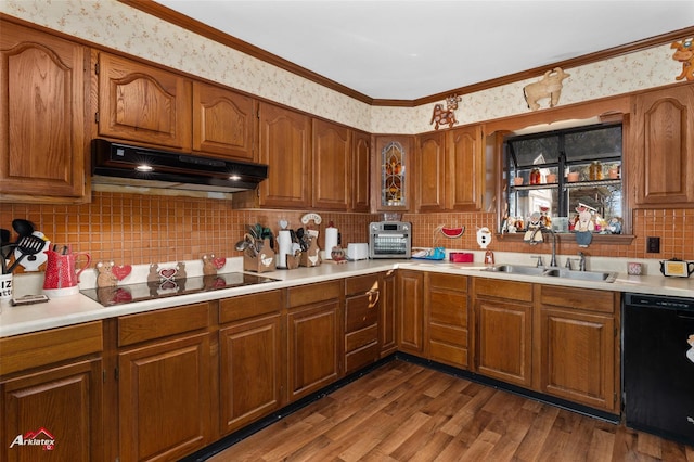 kitchen with ornamental molding, sink, hardwood / wood-style floors, and black appliances