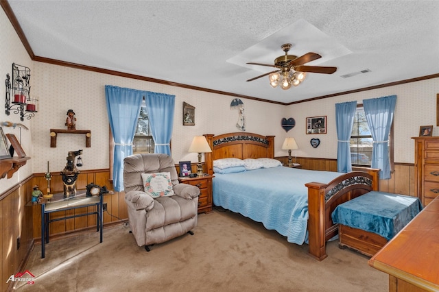 carpeted bedroom featuring a textured ceiling, wooden walls, and ceiling fan