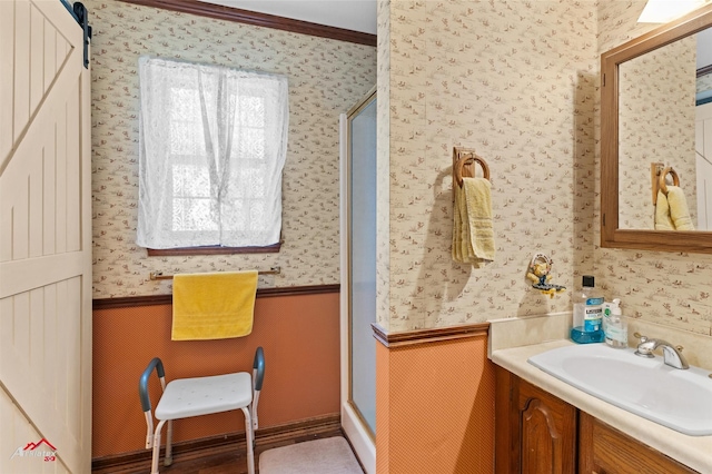 bathroom featuring ornamental molding, vanity, and a shower with shower door