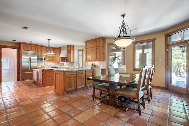 tiled dining room with a notable chandelier and sink