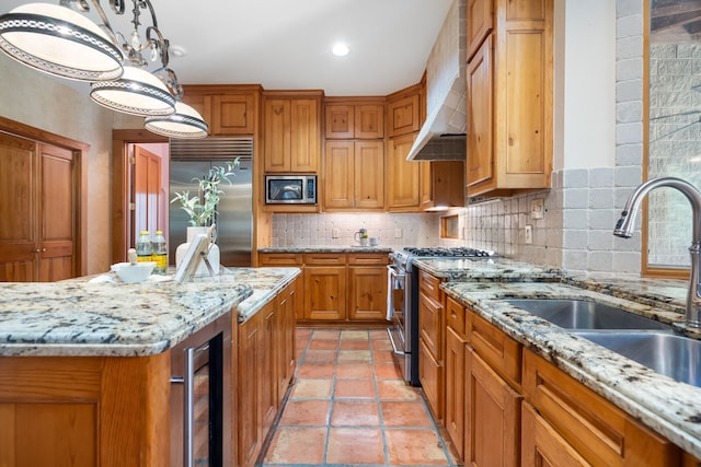 kitchen with sink, built in appliances, wall chimney range hood, beverage cooler, and backsplash