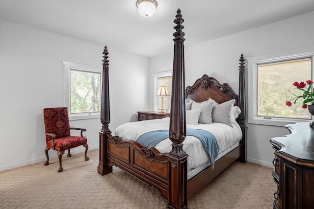 bedroom with light colored carpet and multiple windows