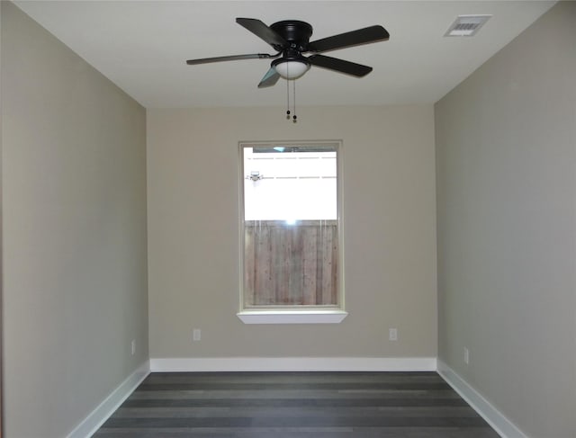 spare room with dark wood-type flooring and ceiling fan