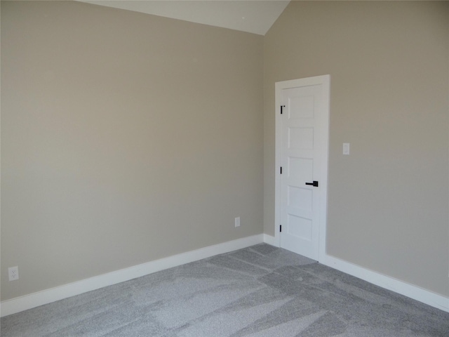 unfurnished room featuring vaulted ceiling and light colored carpet