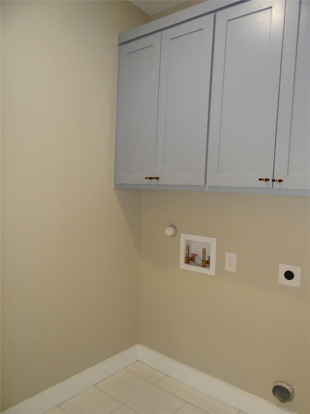 clothes washing area with cabinets, hookup for a washing machine, hookup for an electric dryer, and light tile patterned flooring