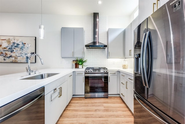 kitchen with gray cabinets, sink, hanging light fixtures, stainless steel appliances, and wall chimney exhaust hood