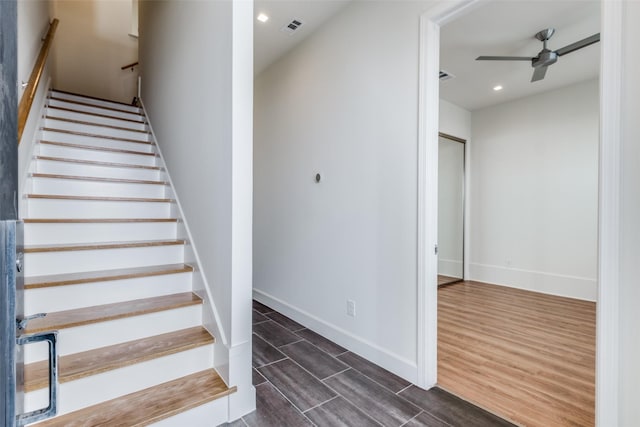 staircase featuring ceiling fan