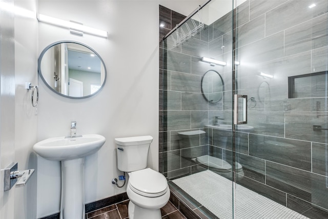 bathroom featuring walk in shower, toilet, and sink