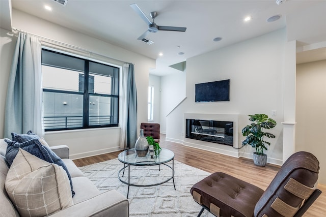 living room with ceiling fan and light hardwood / wood-style floors