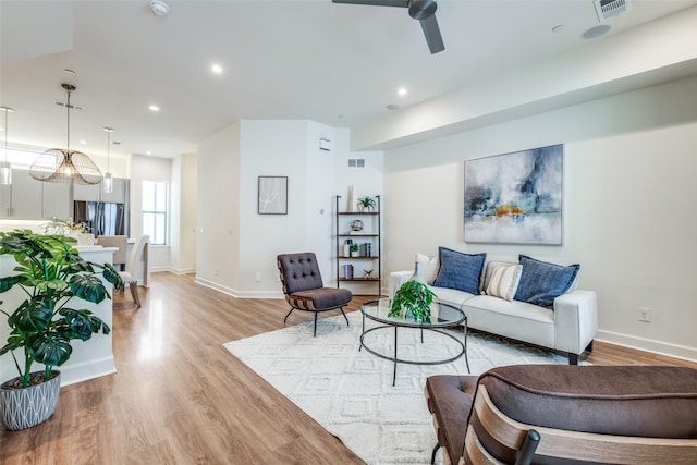 living room with light hardwood / wood-style flooring and ceiling fan