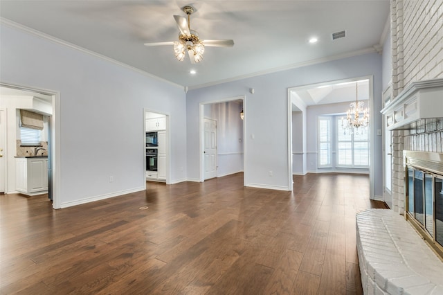 living room featuring dark hardwood / wood-style flooring, crown molding, ceiling fan with notable chandelier, and a fireplace