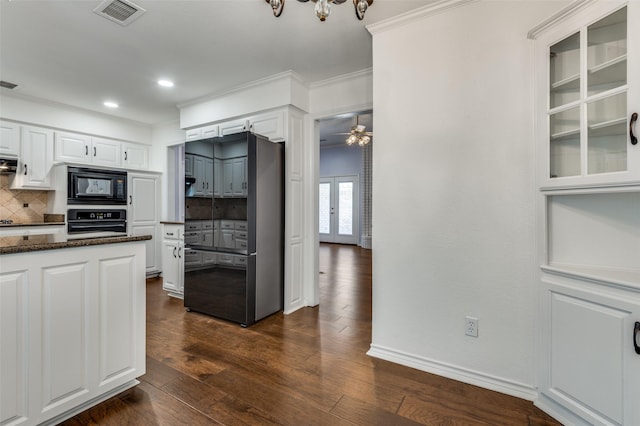 kitchen with dark hardwood / wood-style floors, black microwave, dark stone countertops, oven, and white cabinets