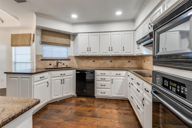 kitchen with dark hardwood / wood-style floors, white cabinetry, sink, dark stone countertops, and black appliances