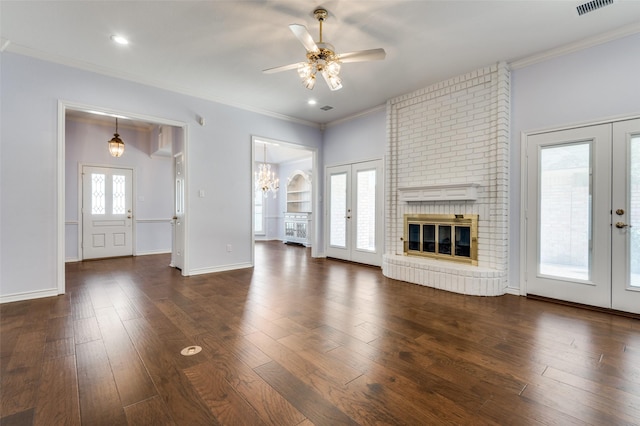 unfurnished living room featuring french doors, a healthy amount of sunlight, ornamental molding, and dark wood-type flooring