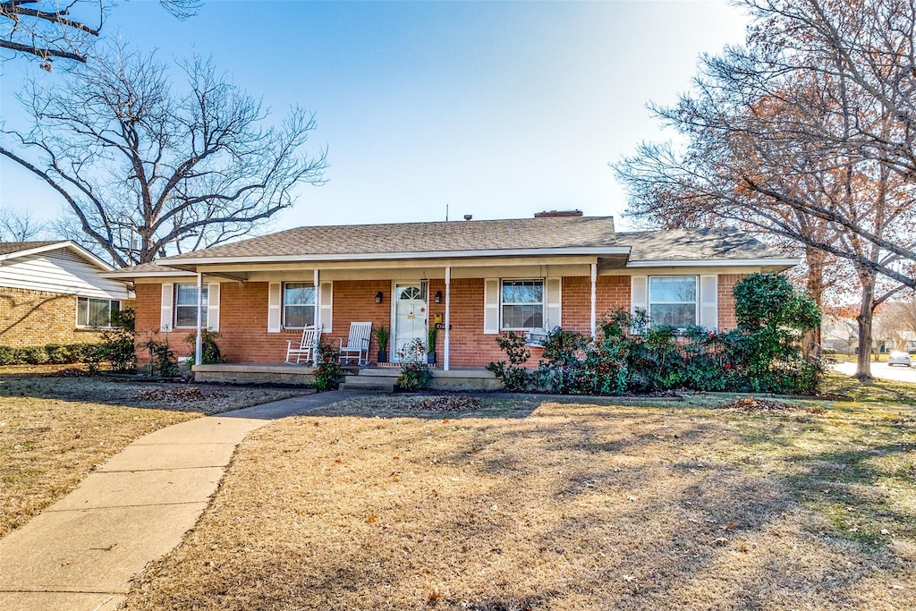 single story home with a porch and a front lawn