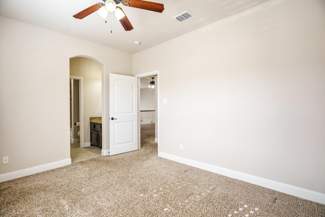 unfurnished bedroom featuring ceiling fan, connected bathroom, and light colored carpet