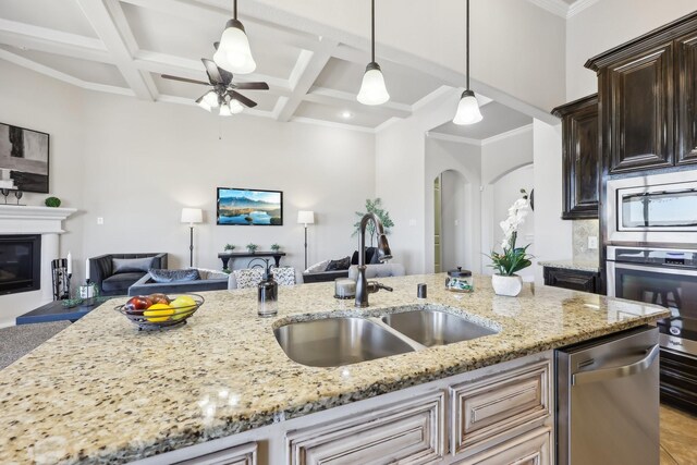 kitchen featuring a breakfast bar, sink, appliances with stainless steel finishes, a kitchen island with sink, and decorative backsplash