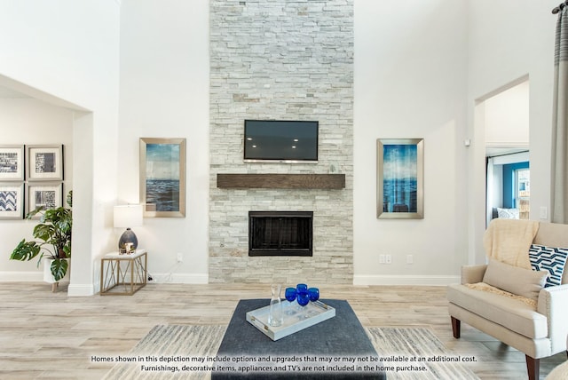 living room featuring a stone fireplace and hardwood / wood-style floors