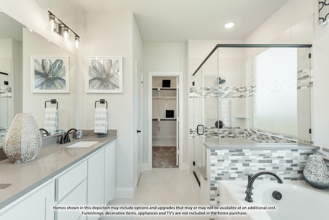 bathroom featuring tile patterned flooring, vanity, and shower with separate bathtub