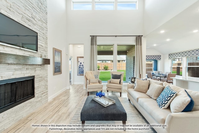 living room featuring a fireplace, light hardwood / wood-style floors, and a healthy amount of sunlight