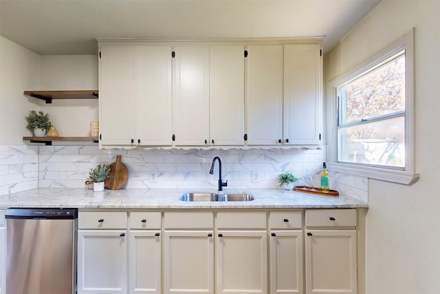2842 Carlson Dr, Dallas, TX 75235 - kitchen with sink, tasteful backsplash, light stone counters, stainless steel dishwasher, and white cabinets