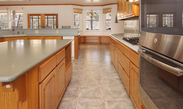 kitchen with a healthy amount of sunlight, appliances with stainless steel finishes, decorative light fixtures, and sink