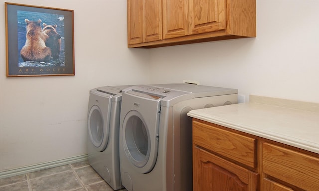 clothes washing area featuring cabinets and washing machine and dryer