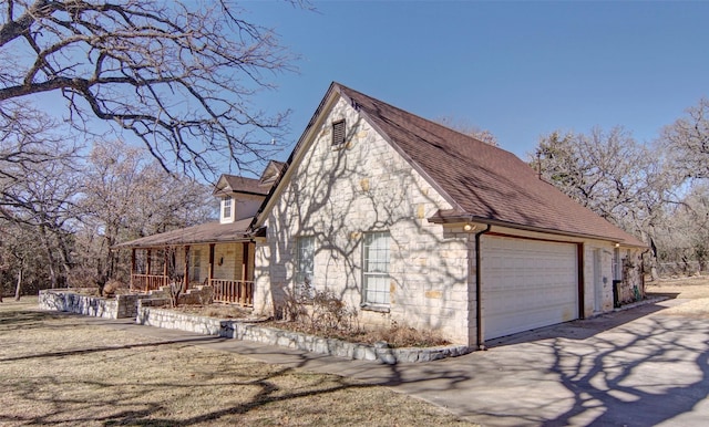 view of home's exterior featuring a garage and covered porch