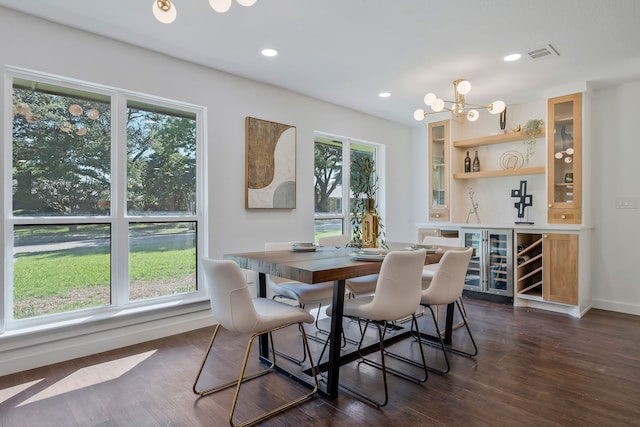 dining area featuring wine cooler, dark hardwood / wood-style flooring, a chandelier, and a wealth of natural light