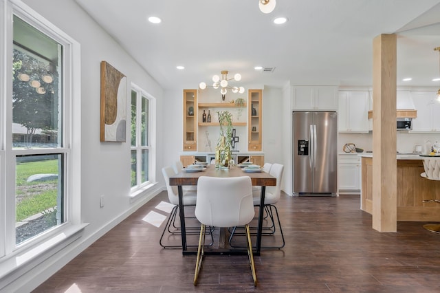 dining area featuring dark wood-type flooring and a chandelier