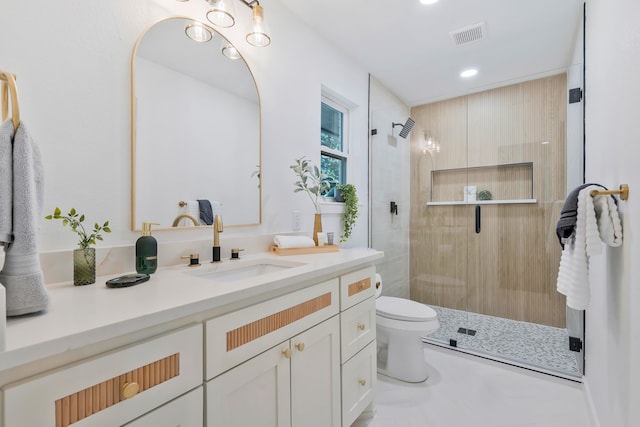 bathroom with vanity, a shower with shower door, and toilet