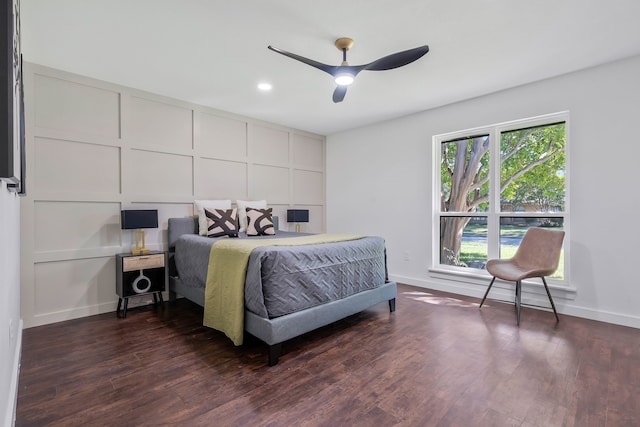 bedroom featuring ceiling fan, dark hardwood / wood-style flooring, and multiple windows