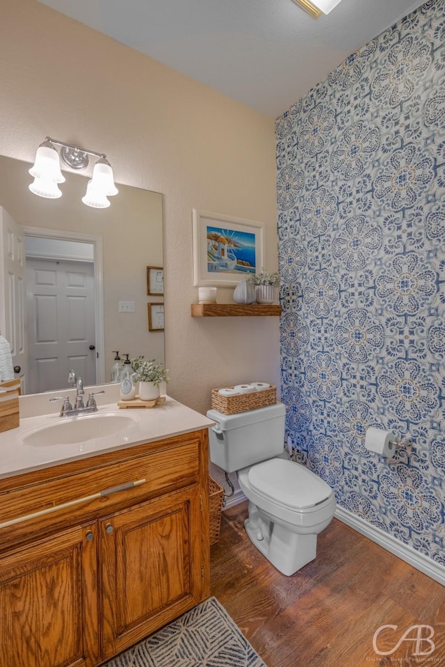 bathroom with vanity, toilet, and hardwood / wood-style floors