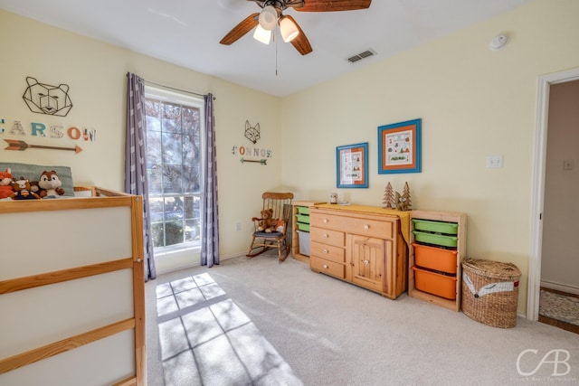 living area featuring light colored carpet and ceiling fan