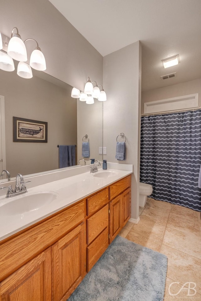 bathroom featuring vanity, tile patterned floors, and toilet