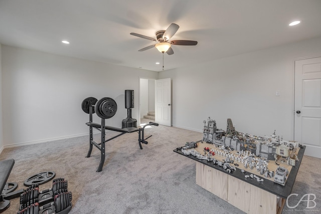 exercise area featuring light colored carpet and ceiling fan