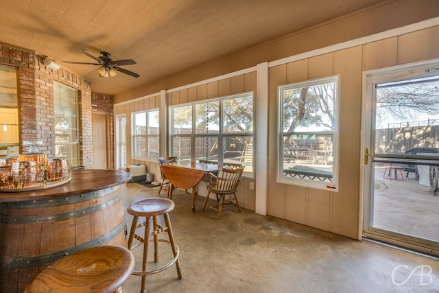 sunroom / solarium featuring plenty of natural light, wooden ceiling, and ceiling fan